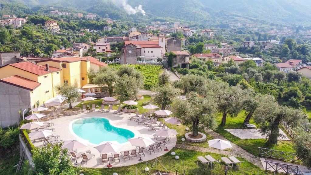 a resort with a pool and chairs and a town at Tenuta Miranda Agriresort in Pimonte