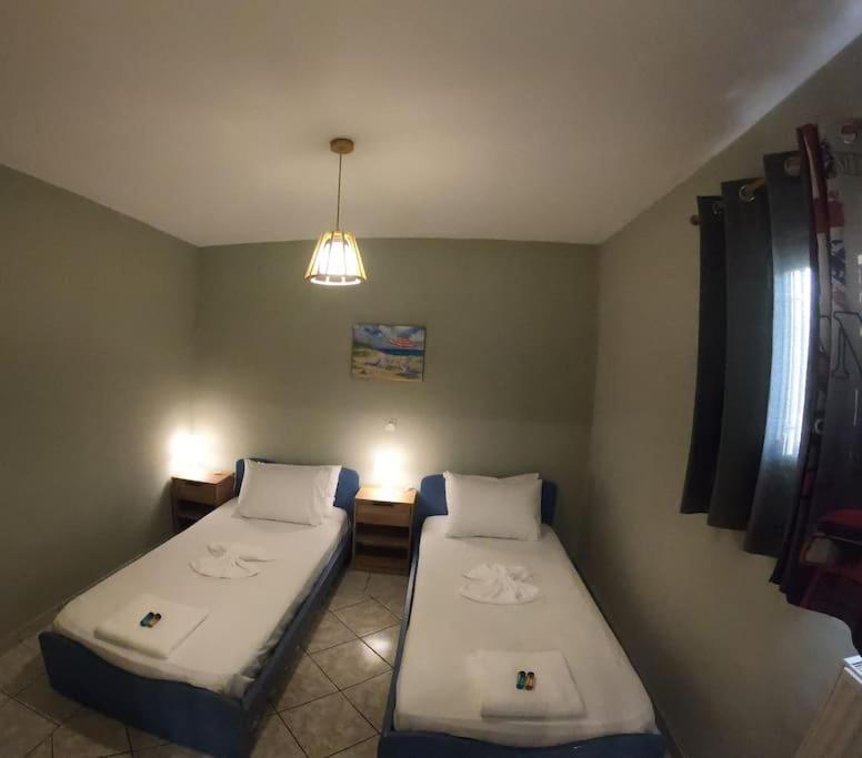 a room with two beds and a light fixture at Mavretas Apartments 4 in Argassi