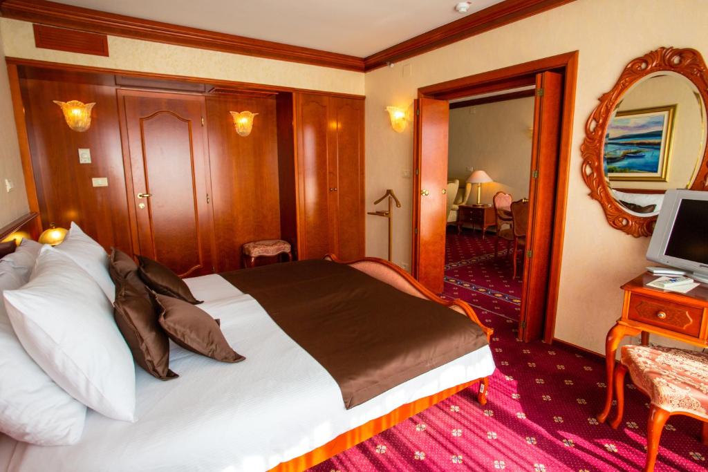 a hotel room with a bed and a mirror at Grand Hotel Bernardin in Portorož