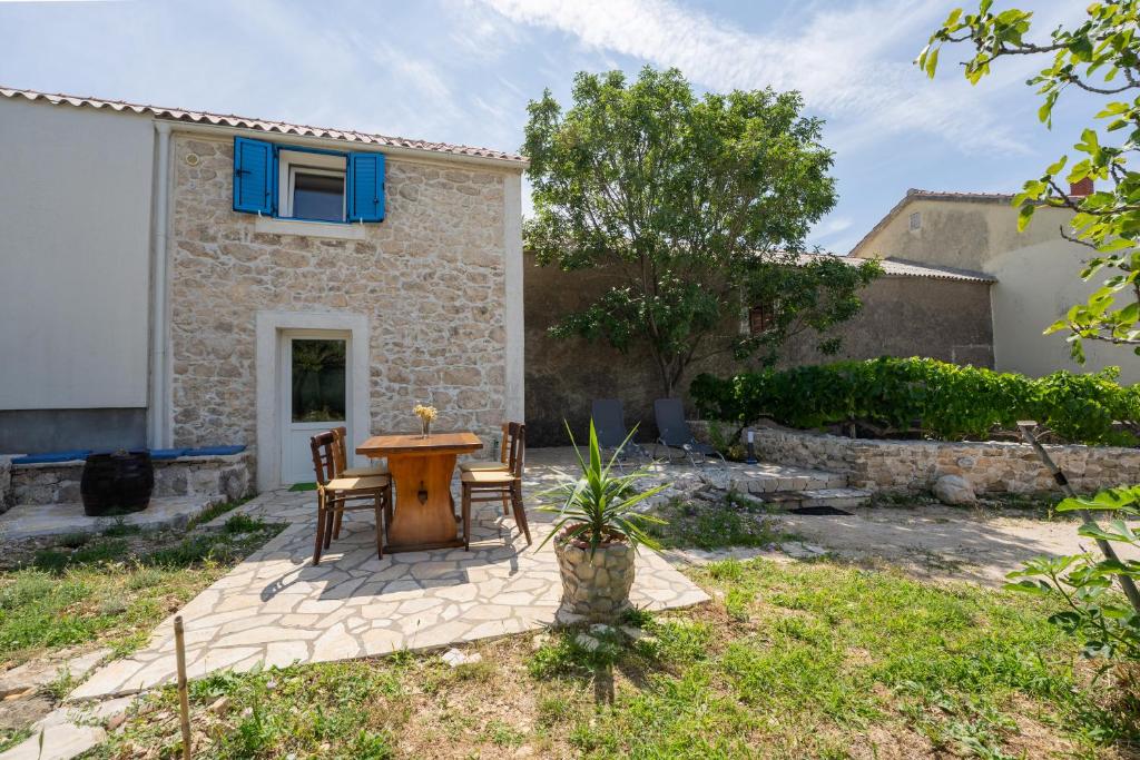 a patio with a table and chairs in front of a house at Kuća za odmor Nikola in Zadar