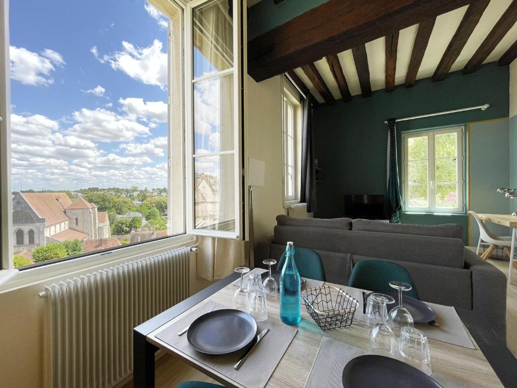 a table in a room with a large window at L'Horizon - Entrée indépendante - Parking in Chartres