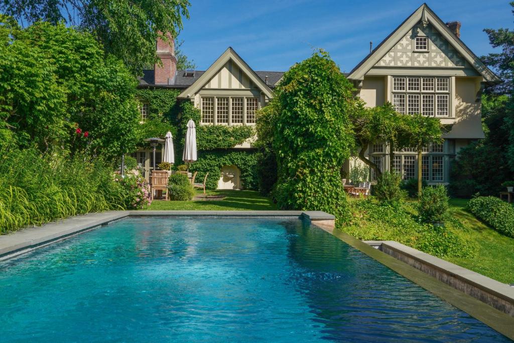 a swimming pool in front of a house at The Baker House 1650 in East Hampton