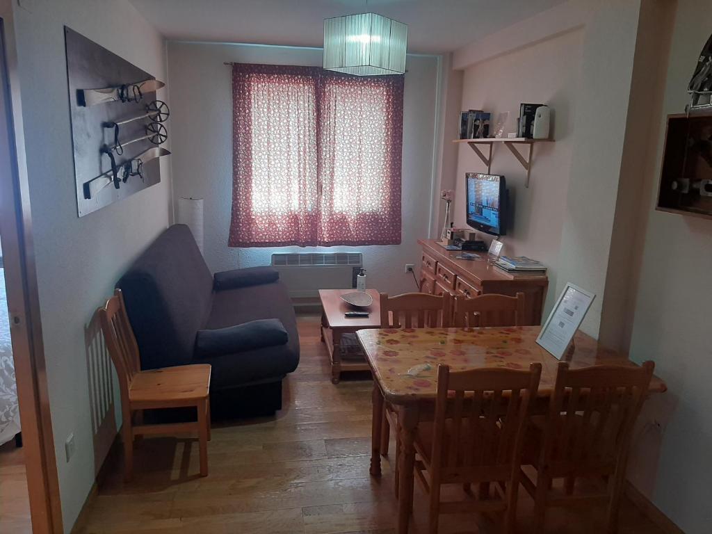 a living room with a table and a blue couch at Apartamento Canfranc in Canfranc-Estación