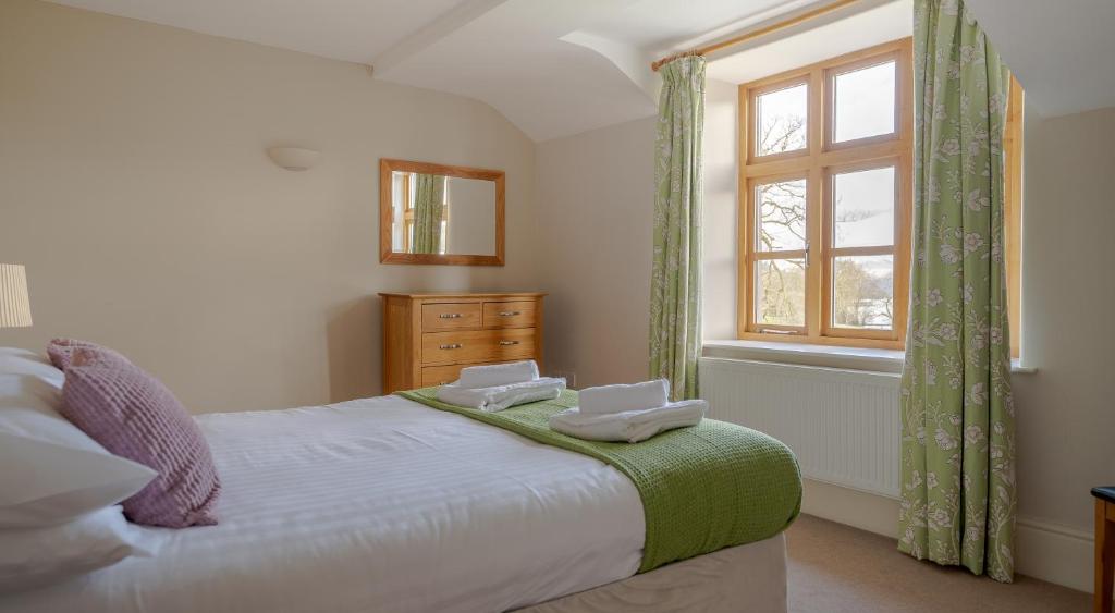 a bedroom with a bed with two towels on it at Mill Cottage in Sawrey