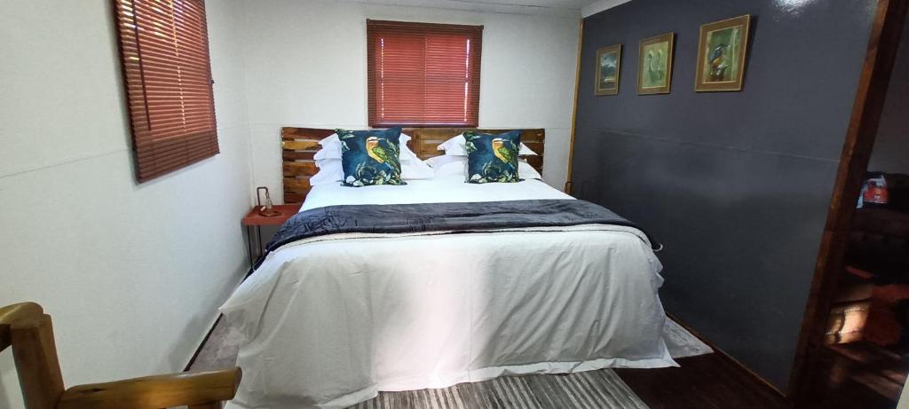 a bedroom with a large bed with blue pillows at Sable Sunset Guesthouse in Trichardt