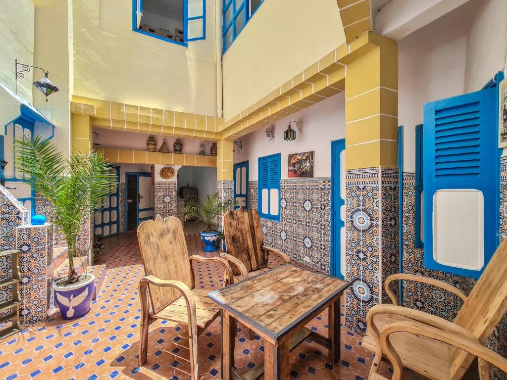 a room with a table and chairs in a building at Riad MIYA in Essaouira