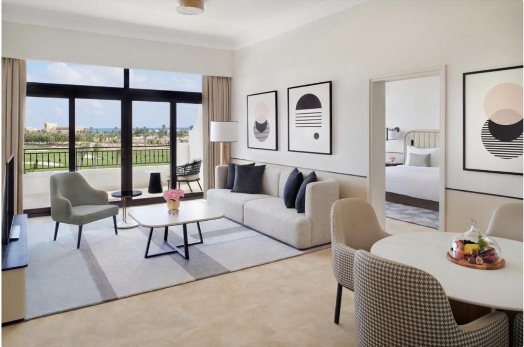 Address Marassi Golf Resort Hotel Appartments في العلمين: غرفة معيشة مع أريكة وطاولة