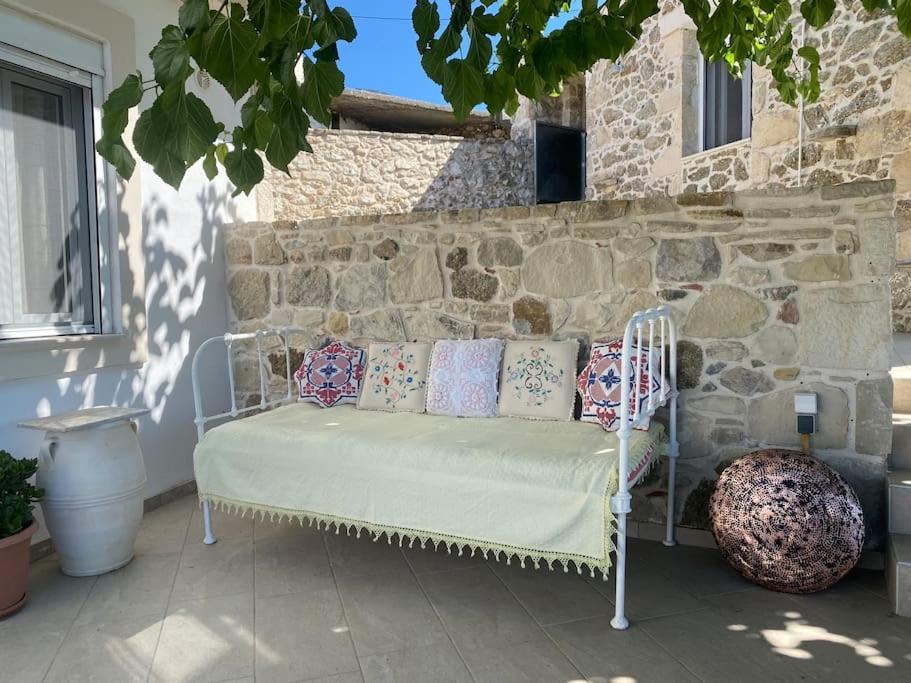 a white bench with pillows on a patio at Asterion Bella View in Zaros