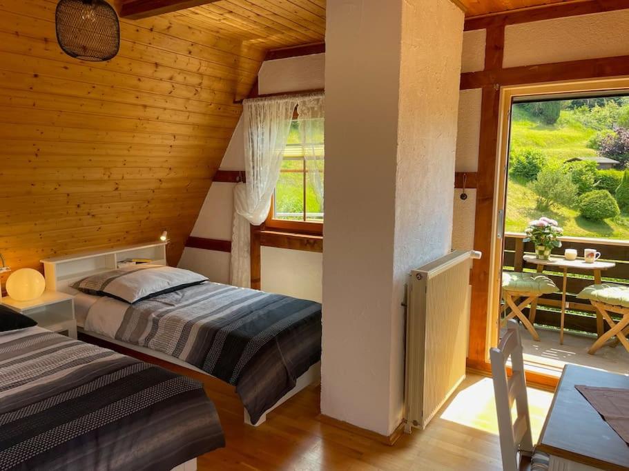 een slaapkamer met een bed en een balkon met een tafel bij Ferienwohnung Baumkrone in Waldeck