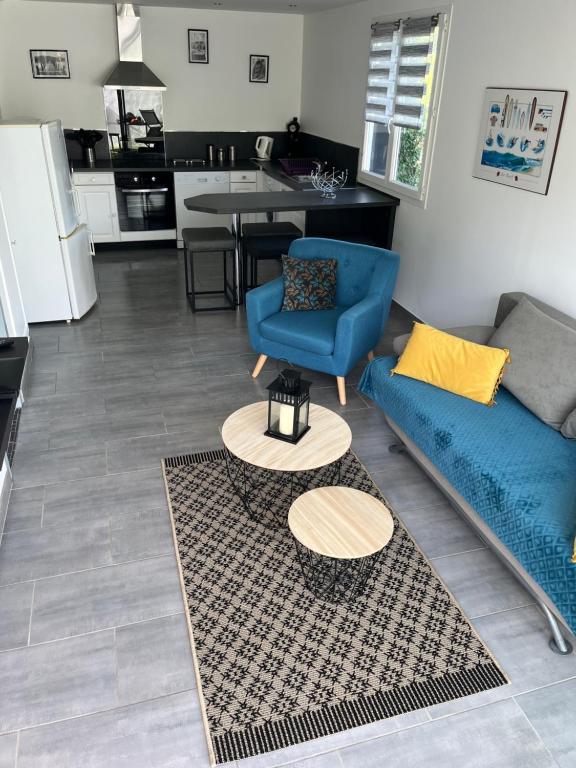 a living room with a blue couch and a table at Gite du Lac in Ondres