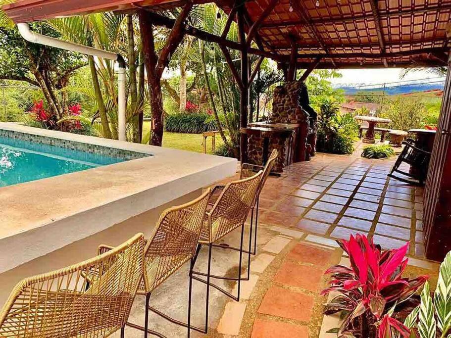eine Terrasse mit Stühlen und einem Pool in der Unterkunft Casa Vacacional Nieves en PZ-Piscina Privada-WIFI in San José