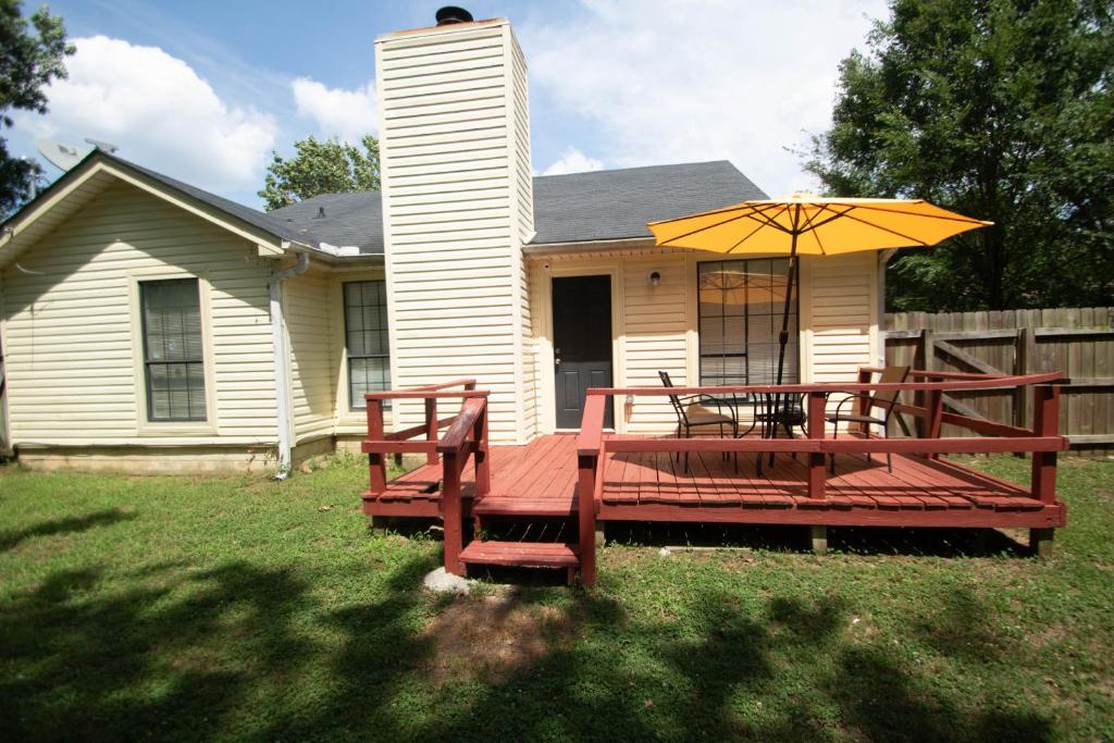 una mesa de picnic y una sombrilla frente a una casa en Home Sweet Home in Camp Robinson, en North Little Rock