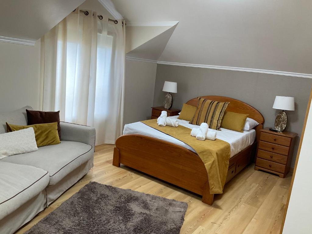 um quarto com uma cama e um sofá em Moniz Apartment em Caniço