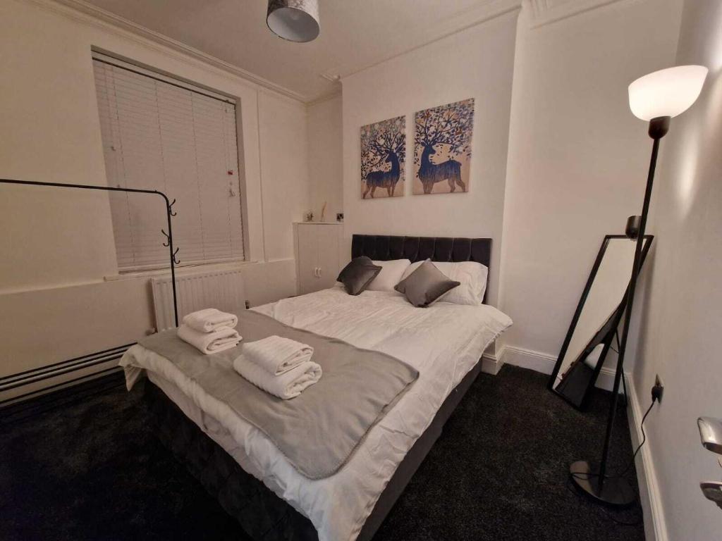 een slaapkamer met een bed met handdoeken erop bij Cyfarthfa House in Cardiff