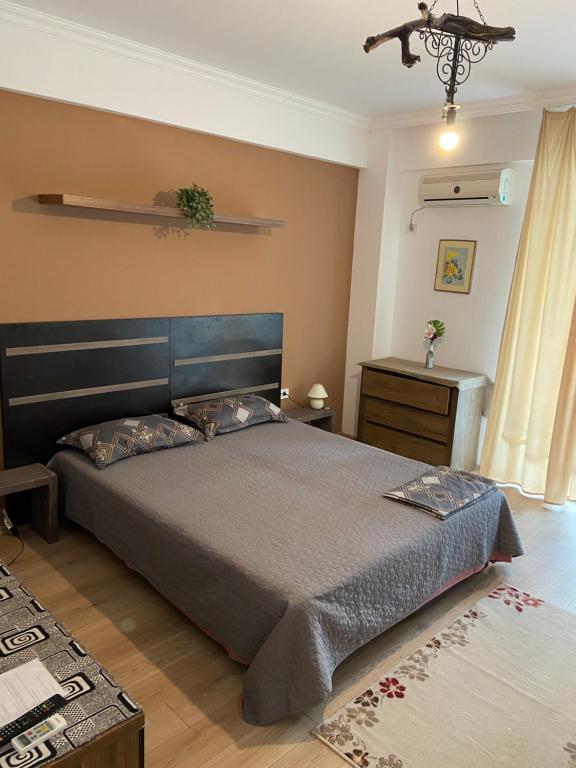 a bedroom with a large bed and a table at Seawave Beach Apartament in Constanţa