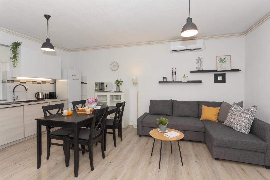 uma sala de estar com um sofá e uma mesa com cadeiras em House for rent Serenity em Skradin