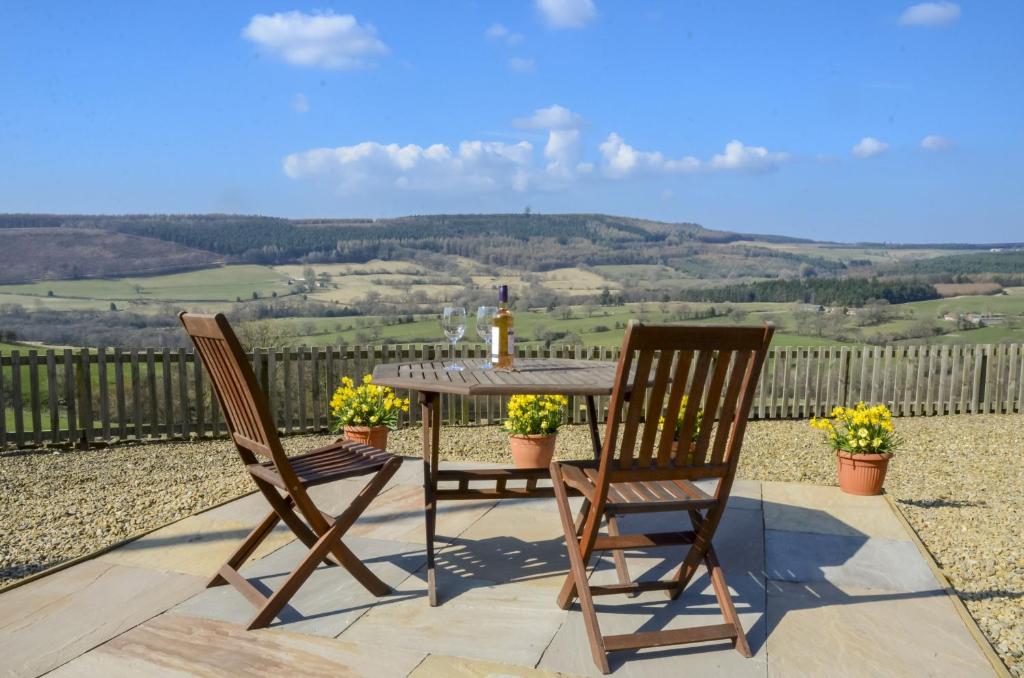 a table and two chairs on a patio with a view at Threp'nybit Cottage in Carlton