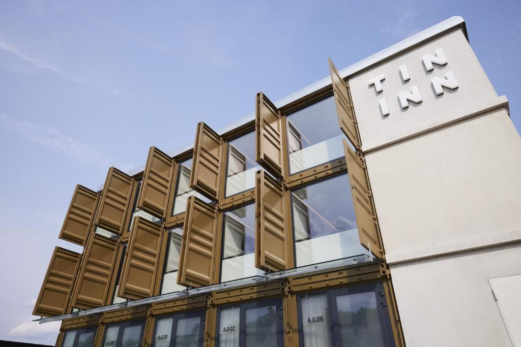 Un edificio con un cartel que dice TMU Inn. en TIN INN Montabaur l einfach gut - Das Hotel aus hochwertig ausgebauten Überseecontainern, en Montabaur