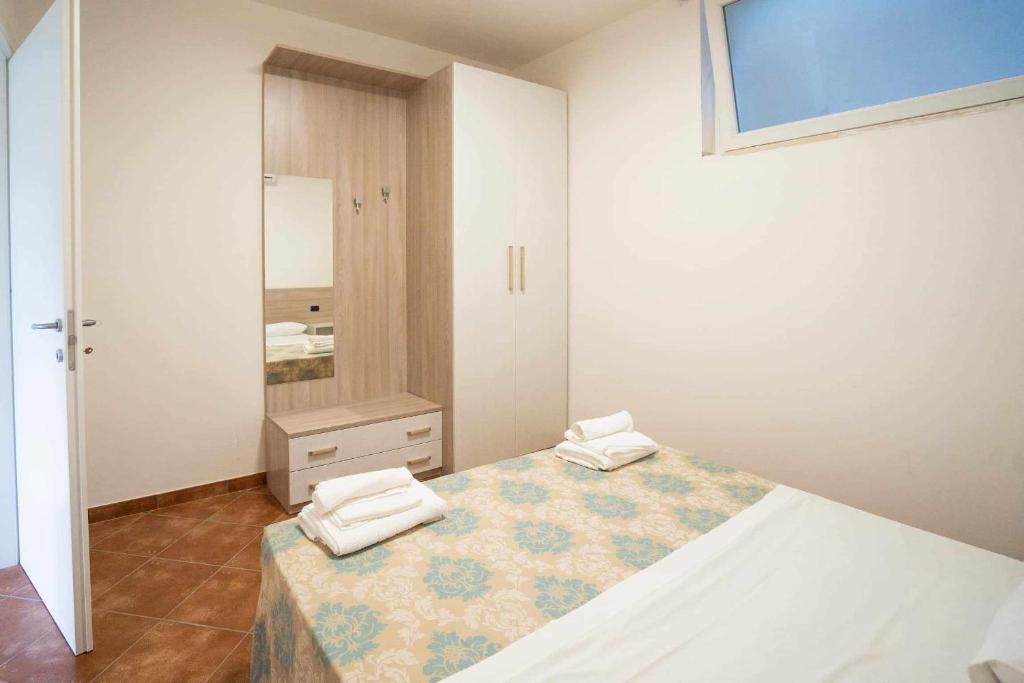 1 dormitorio con 1 cama con 2 toallas en Appartamento Santa Lucia A, en Policastro Bussentino