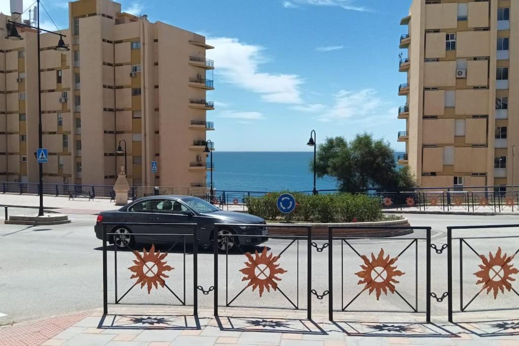 un coche negro aparcado en una calle con edificios en Apartamento en Playa Carvajal, en Fuengirola