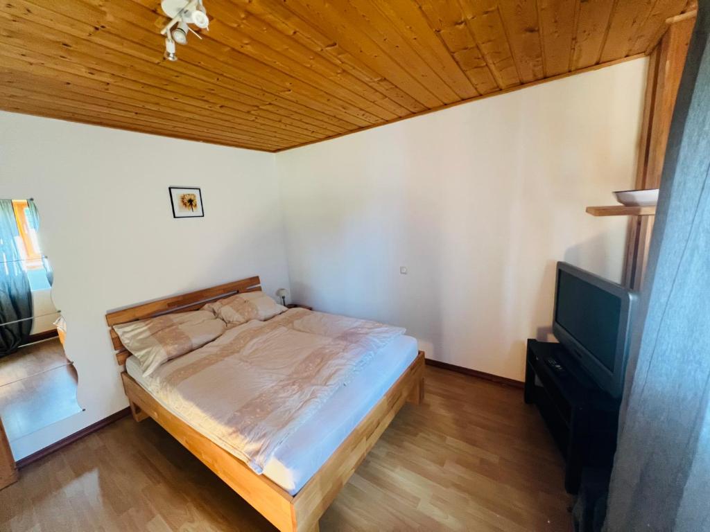 a bedroom with a bed and a wooden ceiling at Ferienwohnung Derscheid in Much