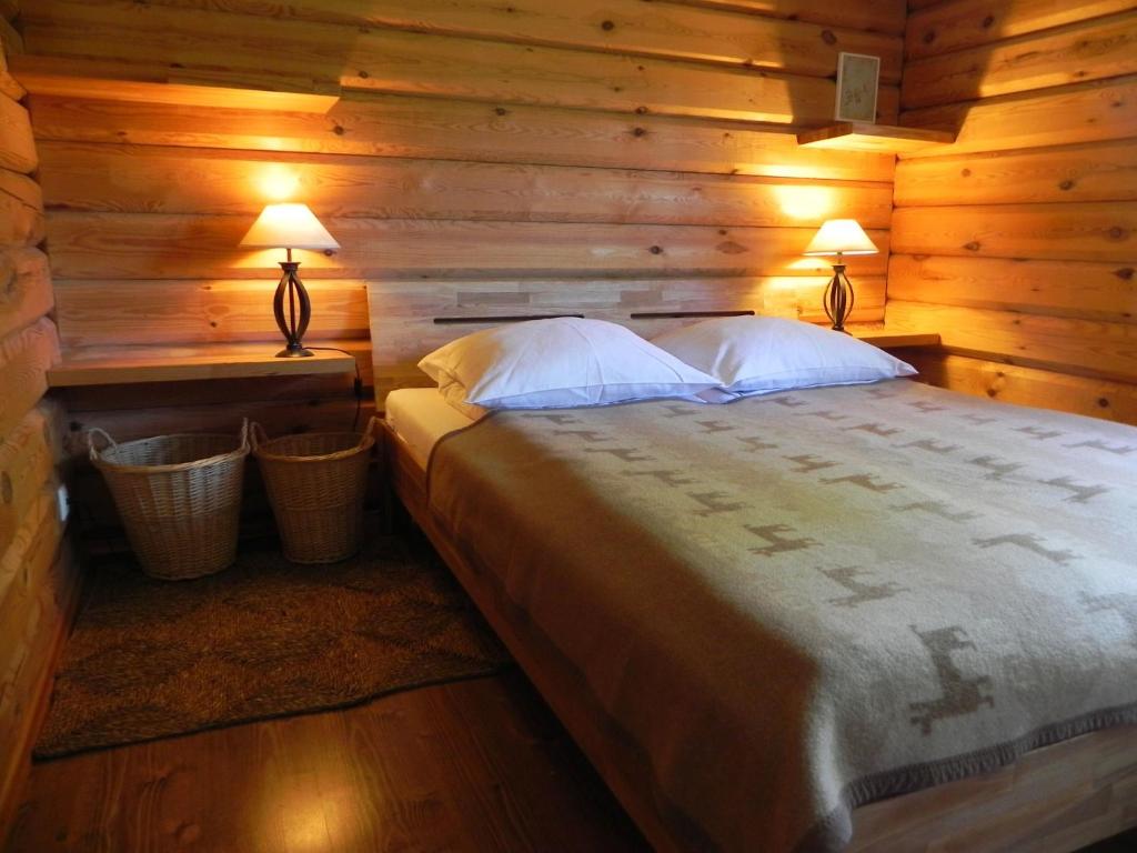 um quarto com uma cama num chalé de madeira em Aliai em Utena