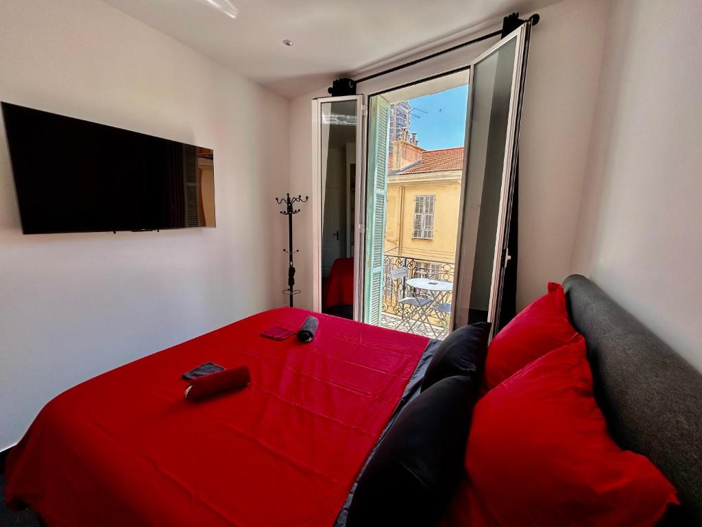 un soggiorno con un letto rosso e una grande finestra di Luxury Monaco ! 7 mins walk to casino square ! Yacht show ! F1 ! 15 sec to Monaco ! a Beausoleil