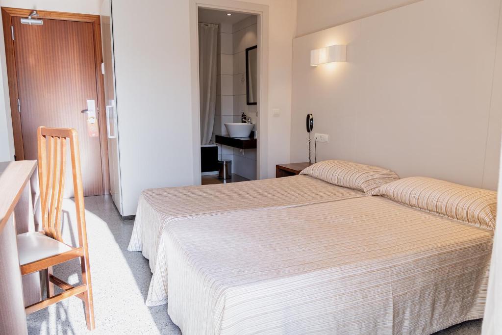 カレーリャにある30º Hotels - Hotel Espanya Calellaのベッドルーム(大型ベッド1台付)、バスルームが備わります。