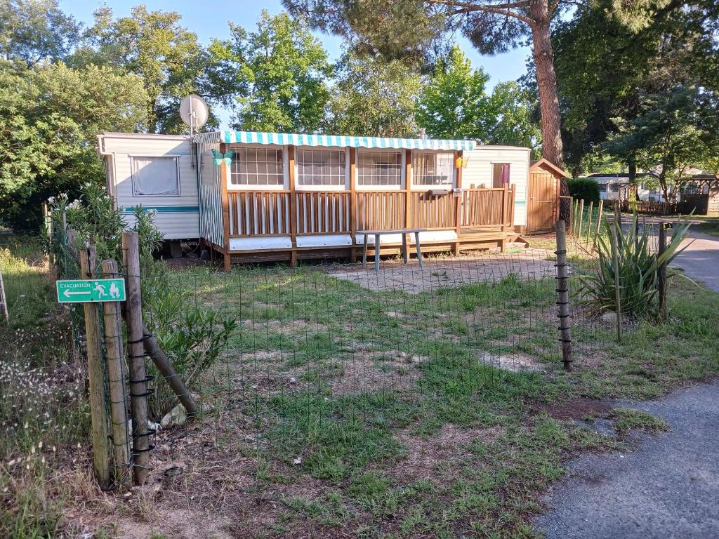 un camping-car est garé dans une cour avec un panneau dans l'établissement MH 343 LA TREMBLADE, à La Tremblade