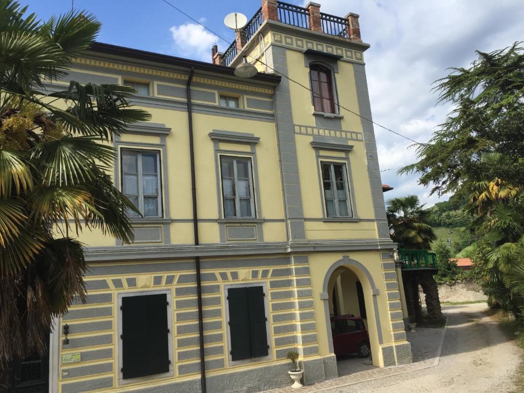 a yellow building with a clock tower on top at Villa Rosi in Cormòns