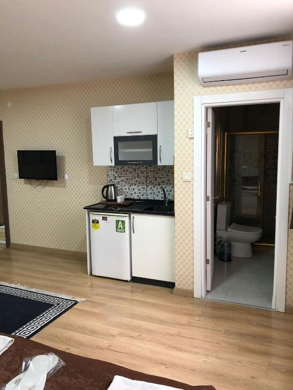 una cocina con armarios blancos y fregadero en malibu palaca, en Estambul