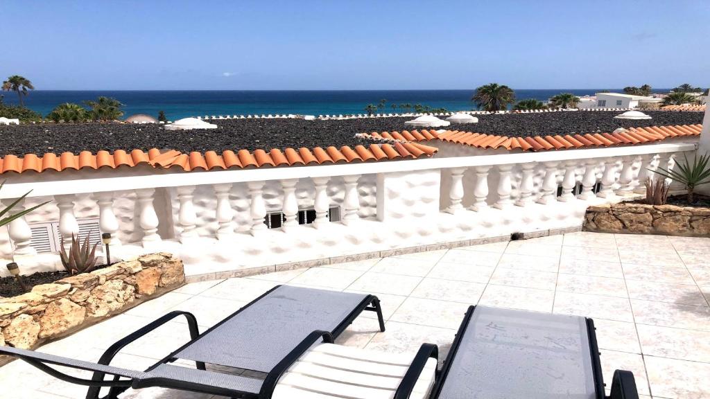 a patio with chairs and the ocean in the background at Welooveyou Top Seaside in Costa Calma