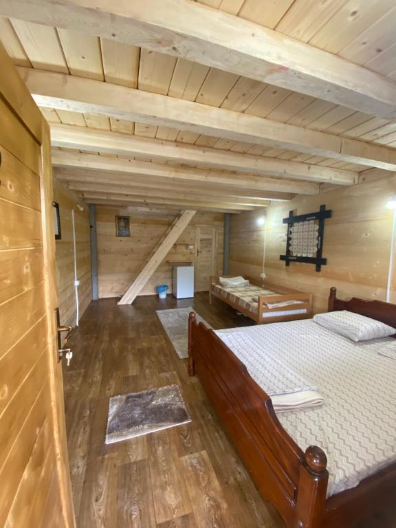 a large room with a bed in a cabin at Wooden houses Bojovic in Gusinje