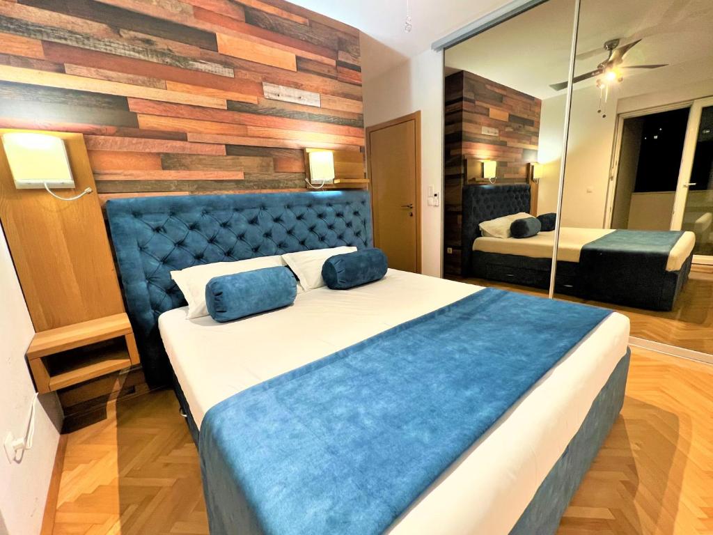 Schlafzimmer mit einem großen Bett mit blauem Kopfteil in der Unterkunft Apartment Makarska, panoramic sea & mountains view, Čuček in Makarska
