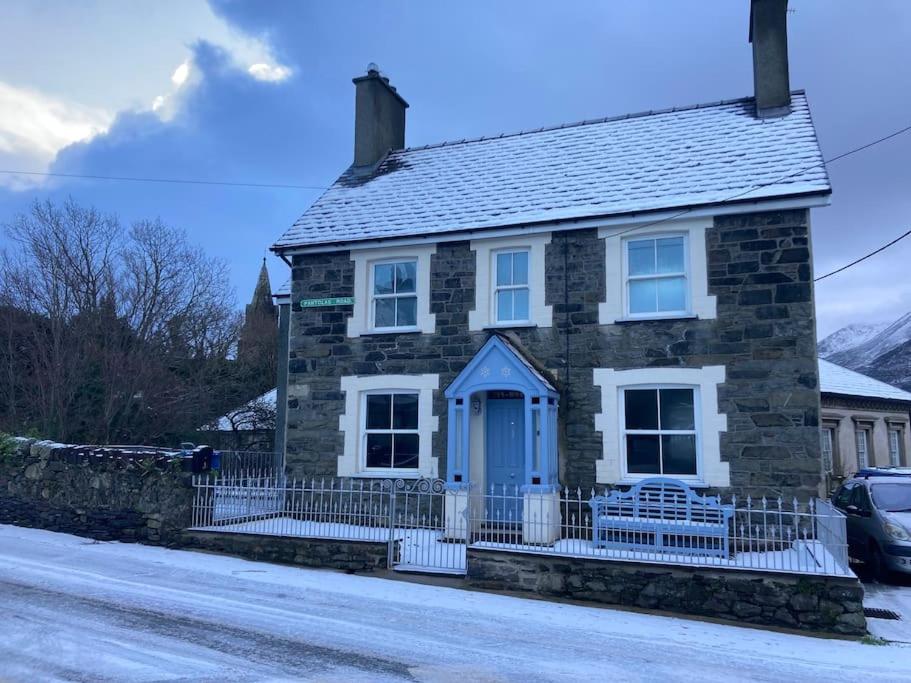 a stone house with a blue door on a street at Ivy House in Bangor