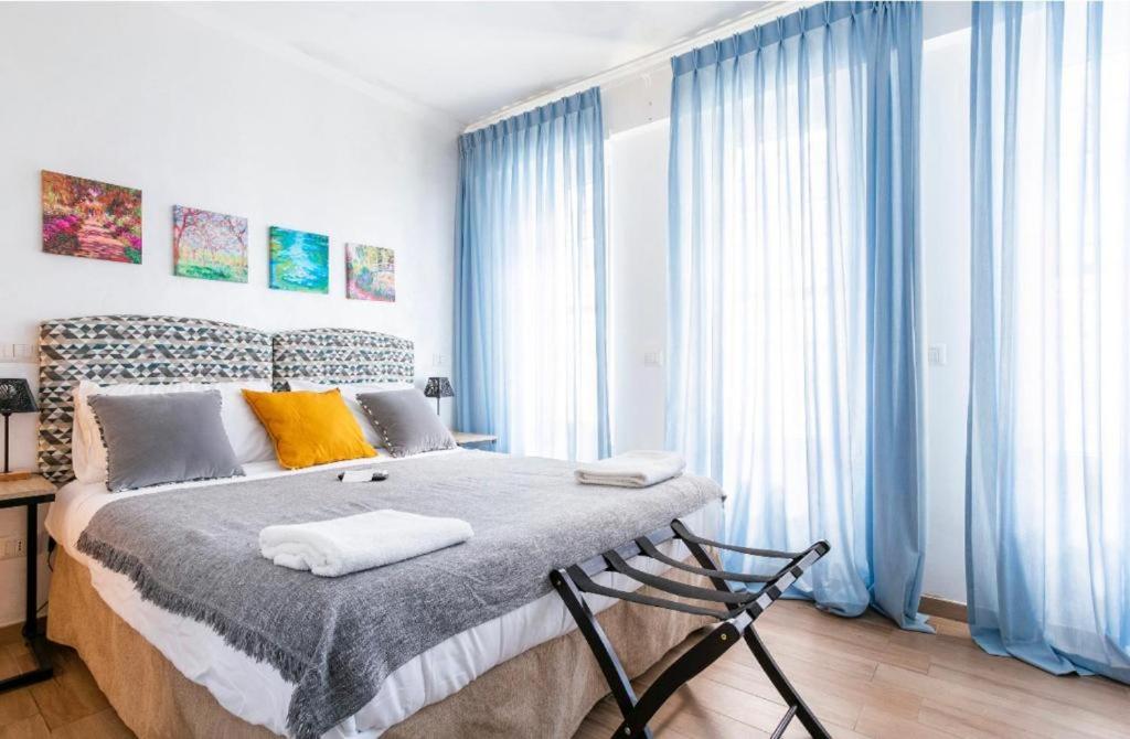 a bedroom with a large bed with blue curtains at Retro Guest House in Rome
