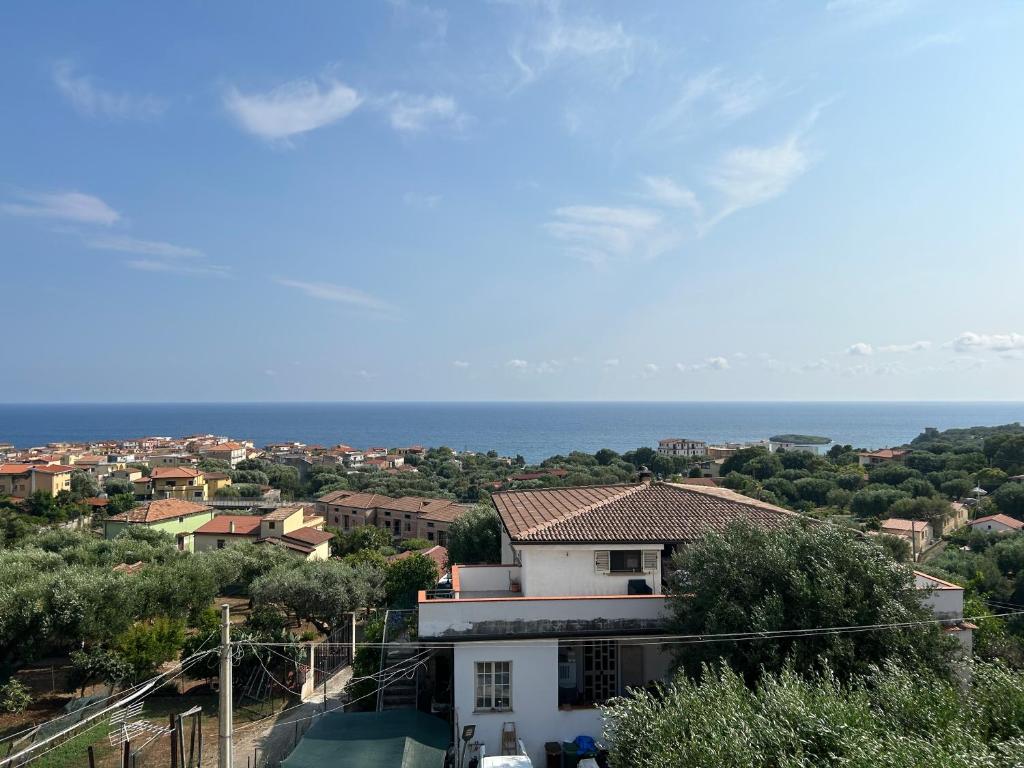 Blick auf ein weißes Haus und das Meer in der Unterkunft Casa vacanze Marina di Camerota in Marina di Camerota
