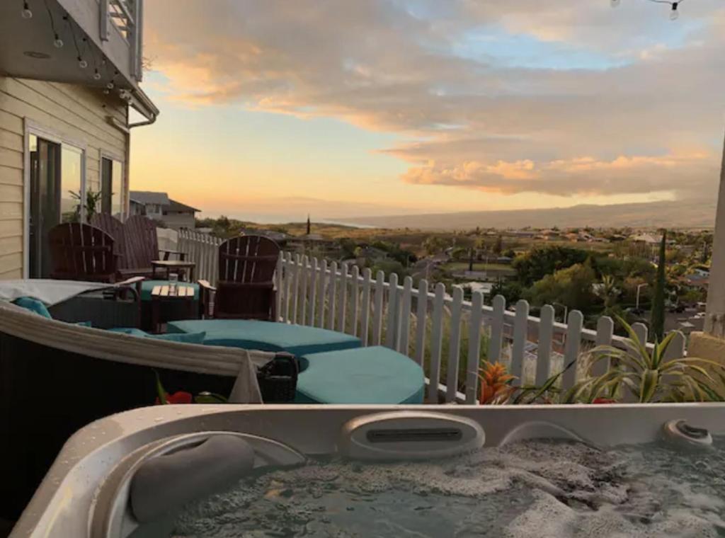 a hot tub on the balcony of a house at Coastal Waikoloa Cottage Sleeps 10 in Waikoloa Village