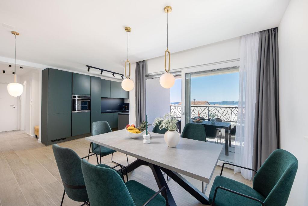 a kitchen and dining room with a table and chairs at Penthouse Apartments East and West Star in Kaštela