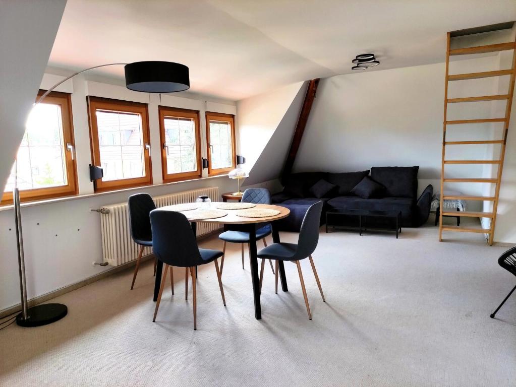 Calma Apartment في فايمار: غرفة معيشة مع طاولة وكراسي وأريكة