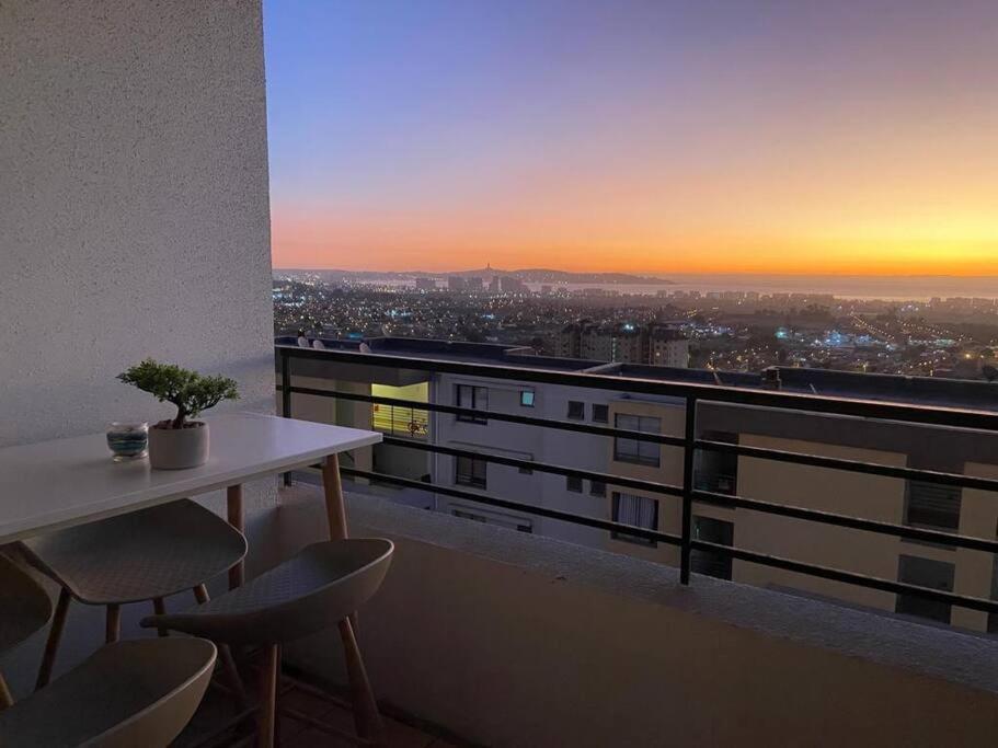 een tafel en stoelen op een balkon met een zonsondergang bij Departamento full equipado, 3 dormitorios in La Serena