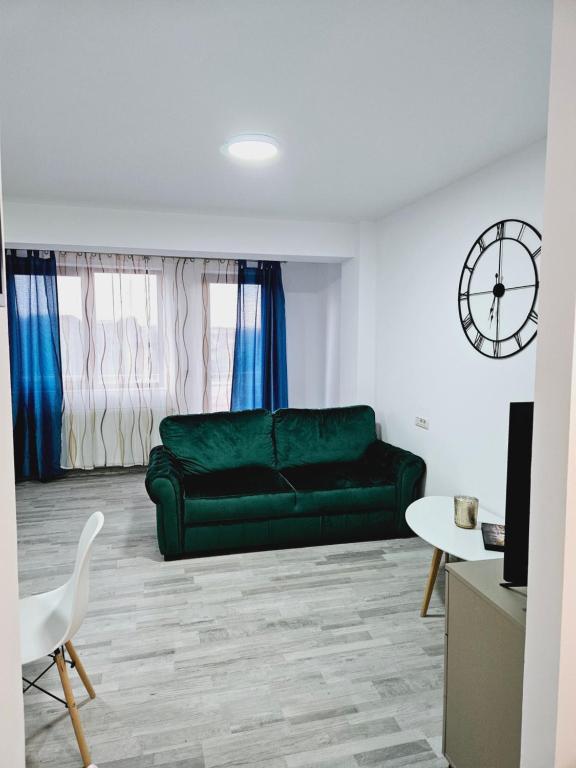 a living room with a green couch and a table at Comapart in Bacău