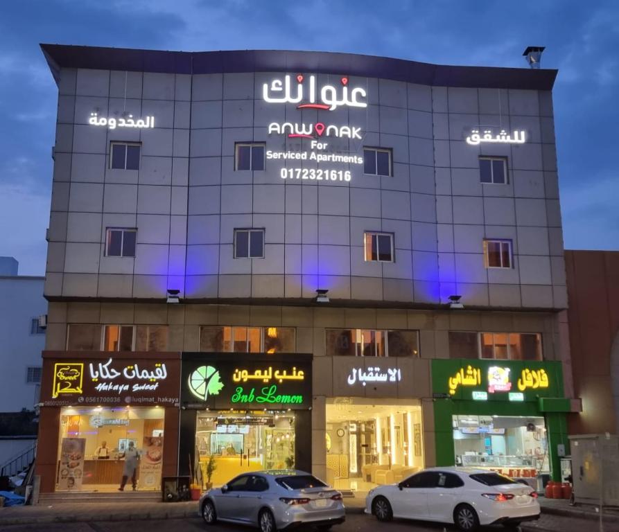un edificio con coches estacionados frente a él en عنوانك للشقق المخدومة, en Abha