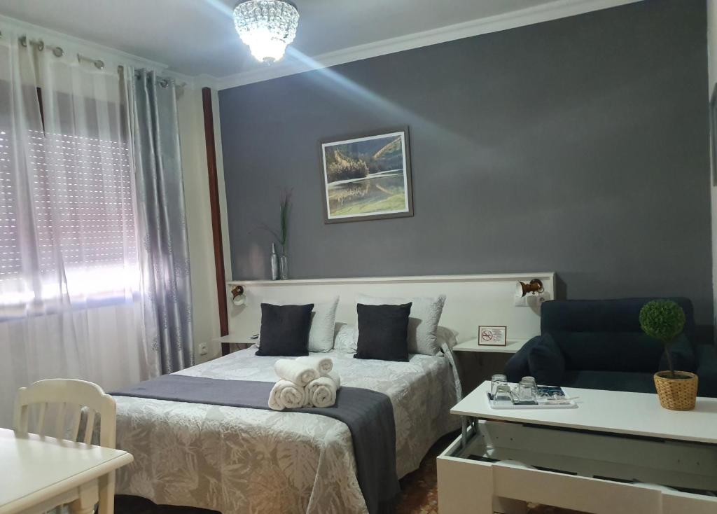 une chambre avec un lit avec deux serviettes dessus dans l'établissement LUNA-Guest Rooms, à Alcalá de Guadaira