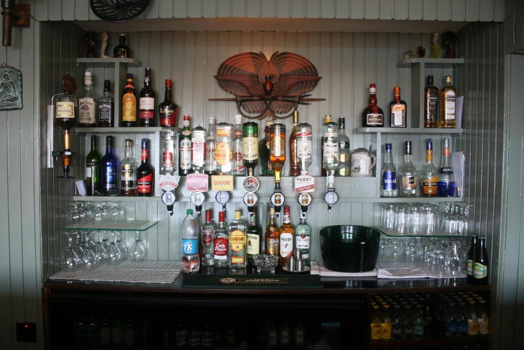 a bar with a lot of bottles of alcohol at Roundstone House Hotel in Roundstone
