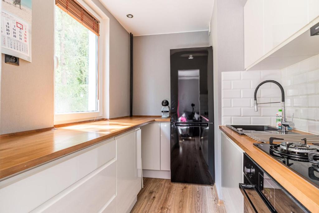 a kitchen with a black refrigerator and a sink at Apartament Black Stripes blisko morza in Gdańsk