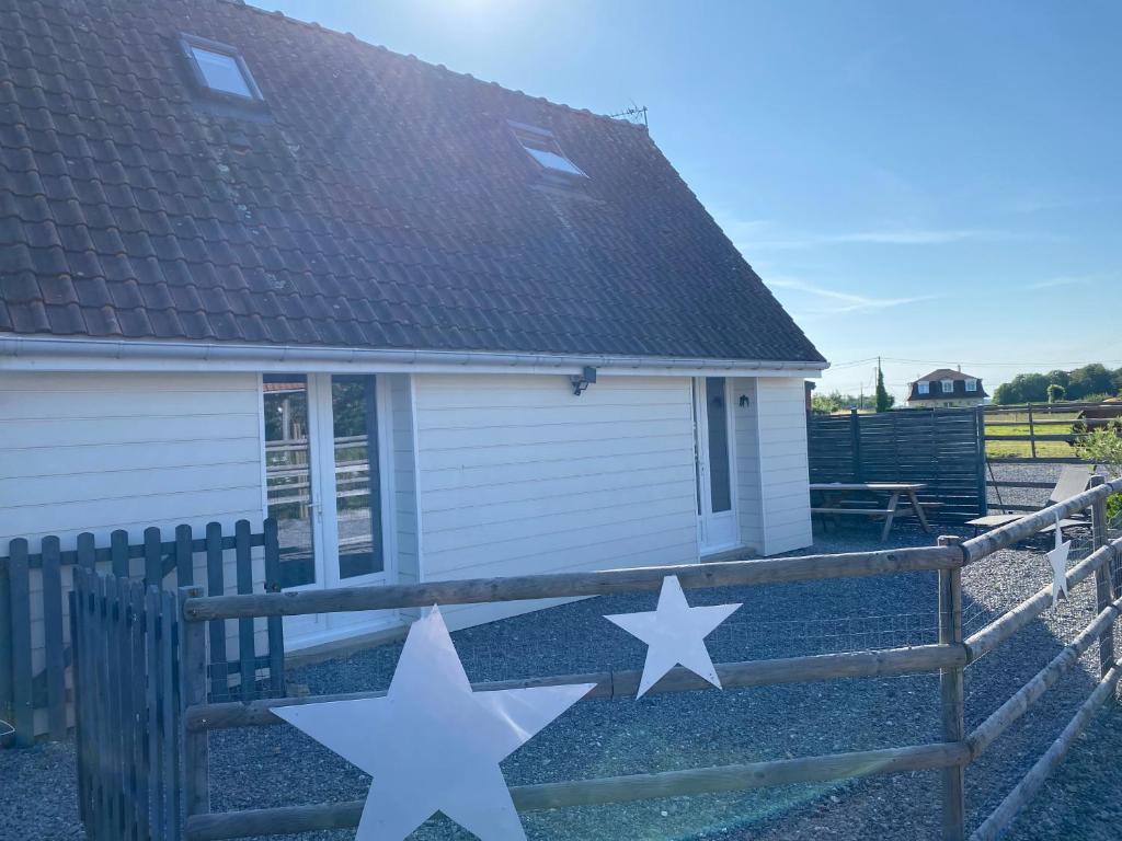 two white stars on a fence in front of a house at gite l'etoile de mer in Eu