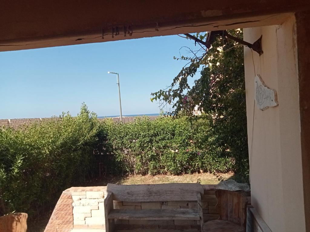 una vista desde el exterior de una casa con un banco en شاليه دور ارضى مدخل خاص يرى البحر en Qaryat Shurūq