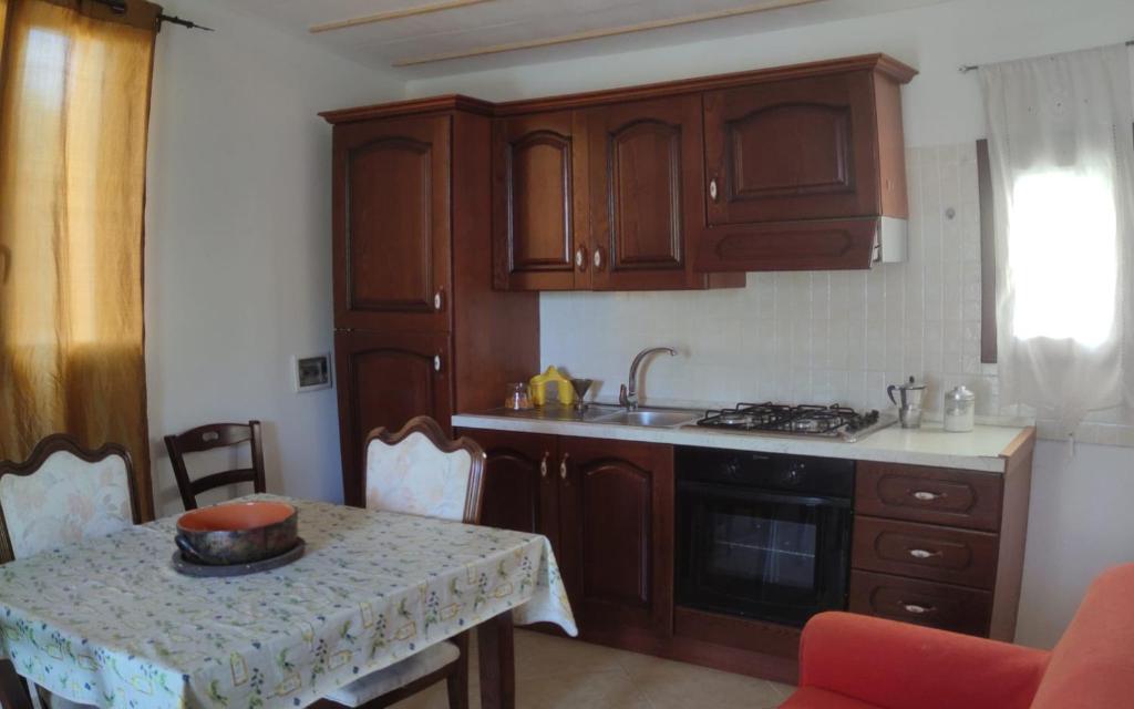 eine Küche mit Holzschränken und einem Tisch mit einer Schüssel darauf in der Unterkunft Casa Borea in Andrano