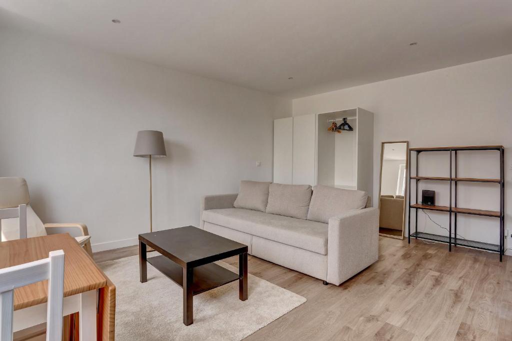 un salon avec un canapé et une table dans l'établissement Le Régent - Versailles, à Versailles